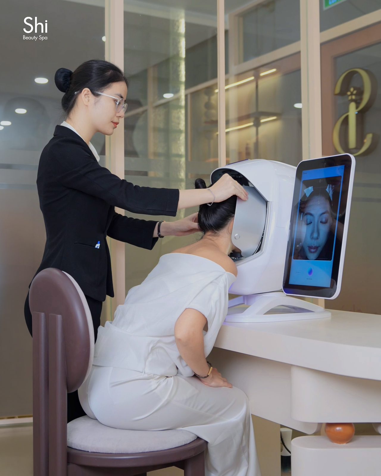Chuyên viên của Shi hướng dẫn khách soi da bằng máy phân tích