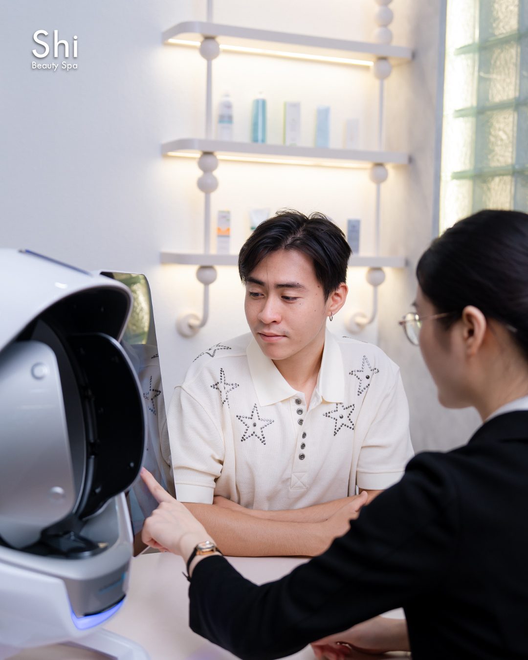 Chuyên viên của Shi tư vấn kết quả soi da cho khách bên máy phân tích