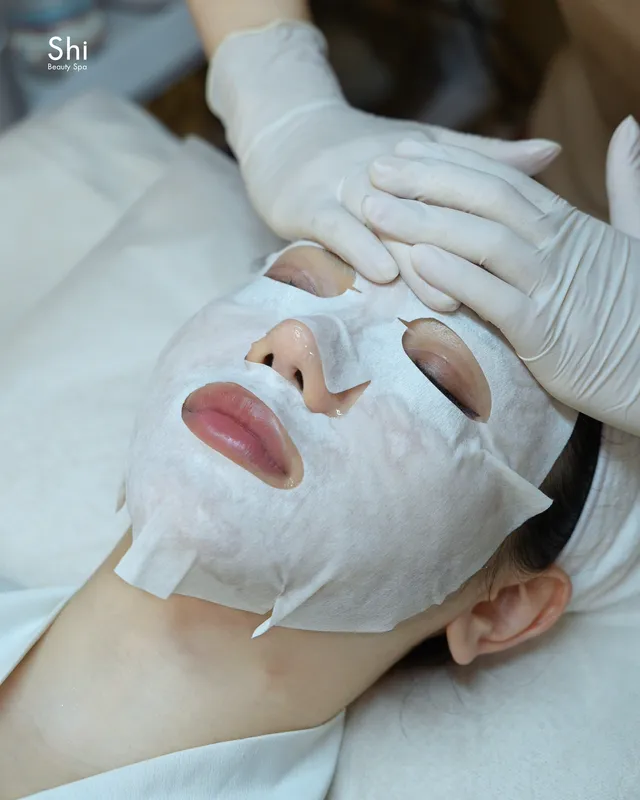 Chuyên viên đeo găng tay đắp mặt nạ cho khách tại Shi