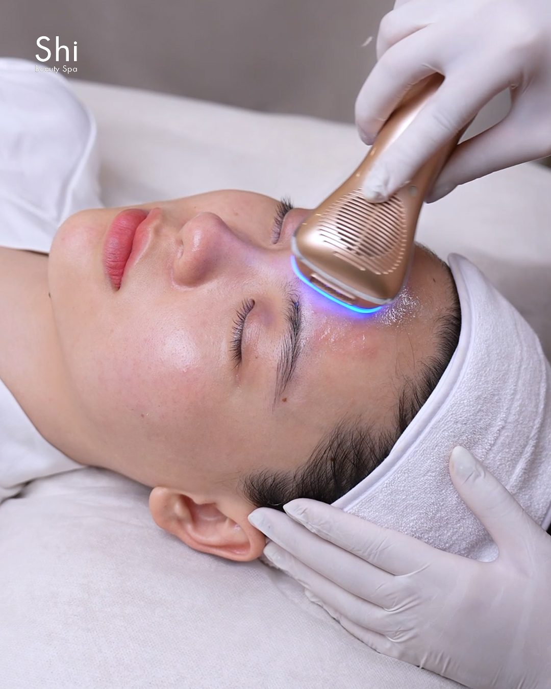 Chuyên viên Shi dùng thiết bị chăm sóc phục hồi da mặt cho khách